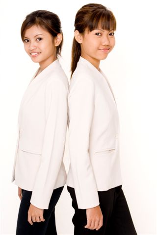 Two attractive young asian women in matching white jackets