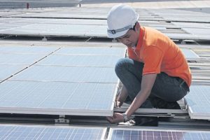 A worker installs solar panels in Samut Prakan province.