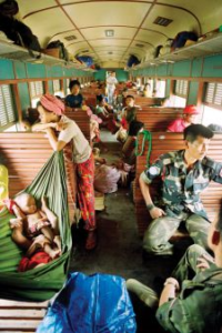 Repatriated refugees on a train from Thailand pass through Kampong Speu on their way home in April 1992, guarded by Malaysian army soldiers.