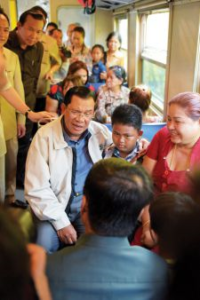 Prime Minister Hun Sen gets up close and personal with fellow passengers during the first trip of the reinstated Phnom Penh to Sihanoukville service last Saturday. 
